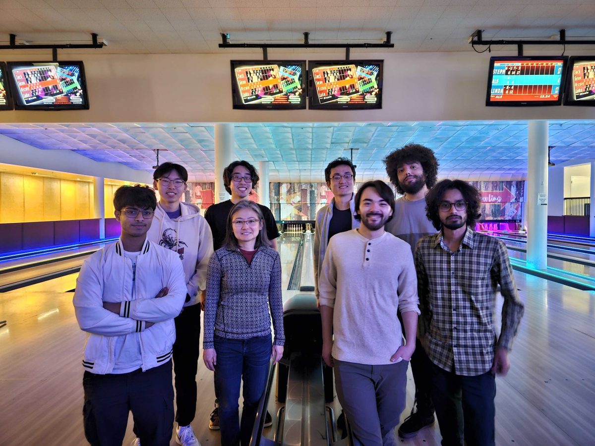 A group photo taken at the UC Davis bowling alley featuring 8 members of the Takamura Research Group