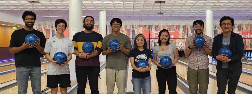Group photo at the UC Davis bowling alley with 7 students and Prof. Takamura holding blue bowling balls