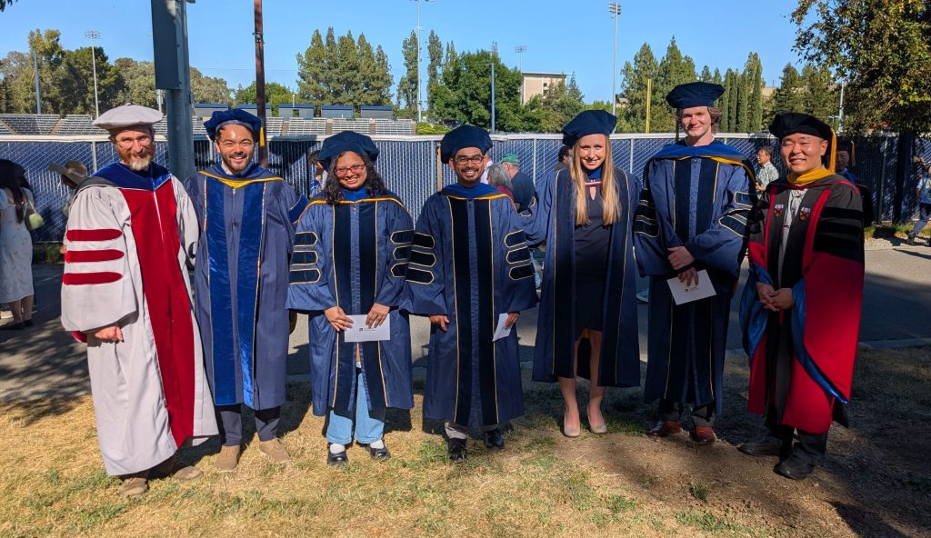 A line of faculty and students in their graduation gowns